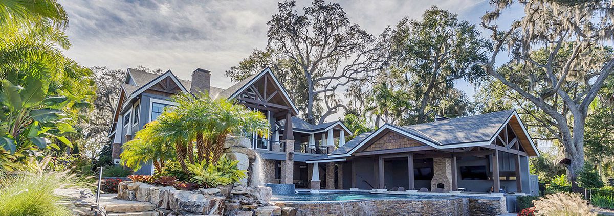 Orlando backyard privacy landscaping by BLG Environmental Services with mature shade trees, natural screening plants, and luxury hardscape design.