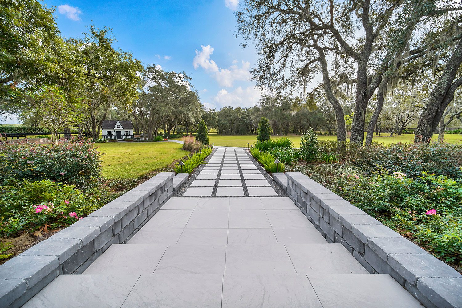 Property-wide landscape modernization featuring integrated hardscape, mature landscaping, circulation pathways, and cohesive estate landscape design